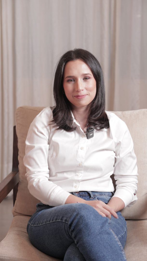Gisell en un sillón, con camisa blanca